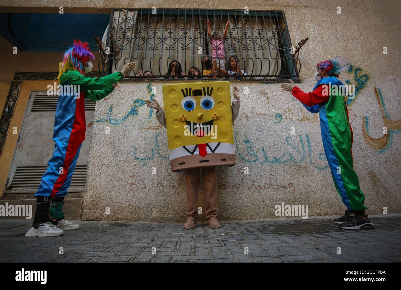 Gaza, Palestine. 10th Sep, 2020. Palestinian youths dressed as clowns and one as SpongeBob while wearing face masks as a preventive measure staged a street performance to entertain children trapped at home due to the Coronavirus outbreak in Khan Yunis, southern Gaza Strip. Credit: SOPA Images Limited/Alamy Live News Stock Photo