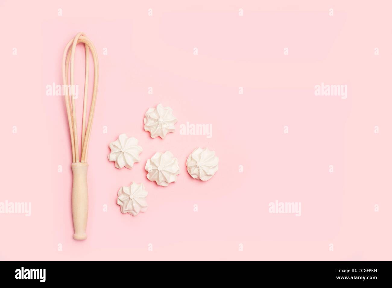 Meringues and an egg beater on a pink background in a top view Stock Photo Alamy