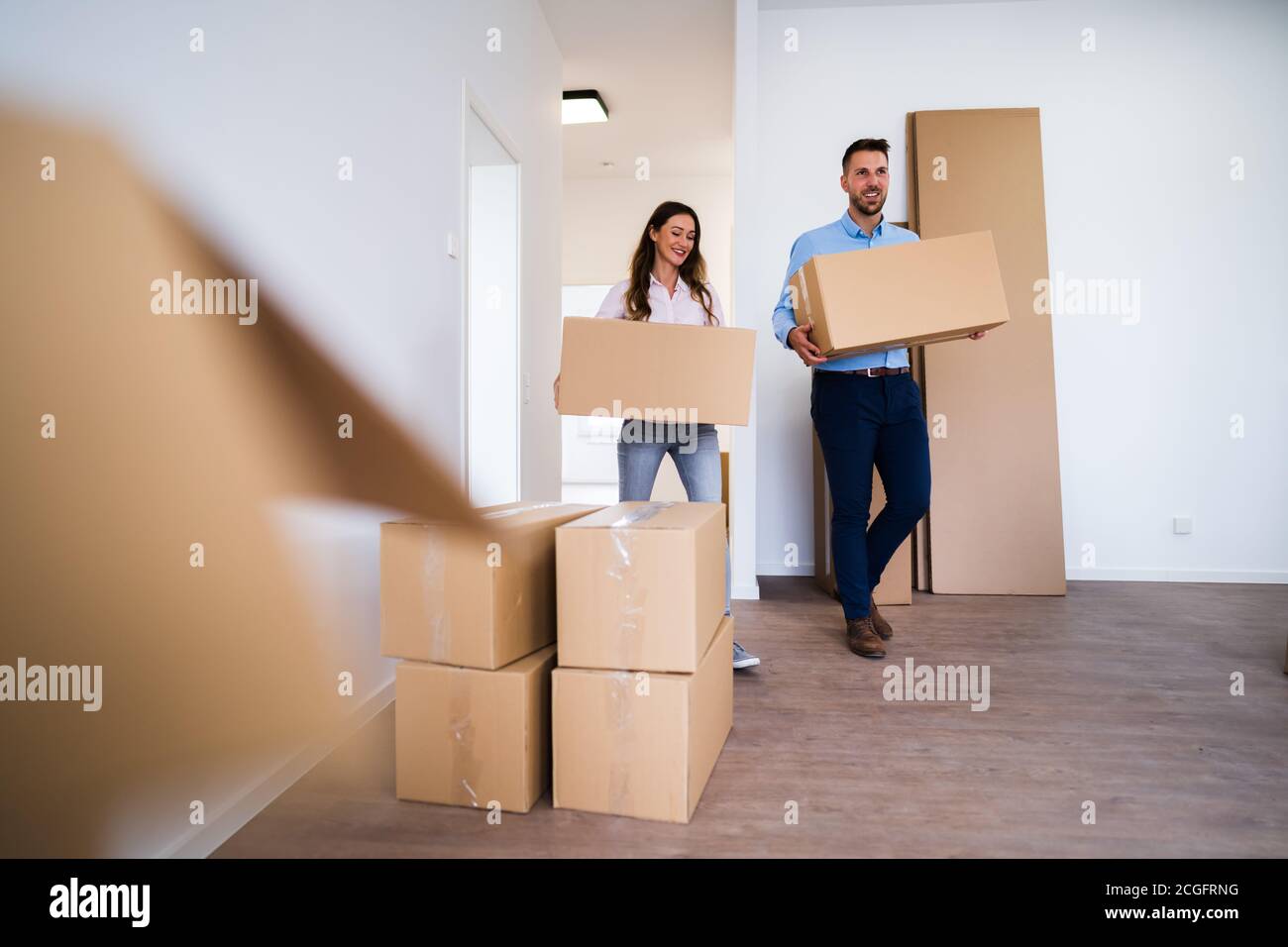 Family Relocation Carrying Boxes Into New Home Stock Photo