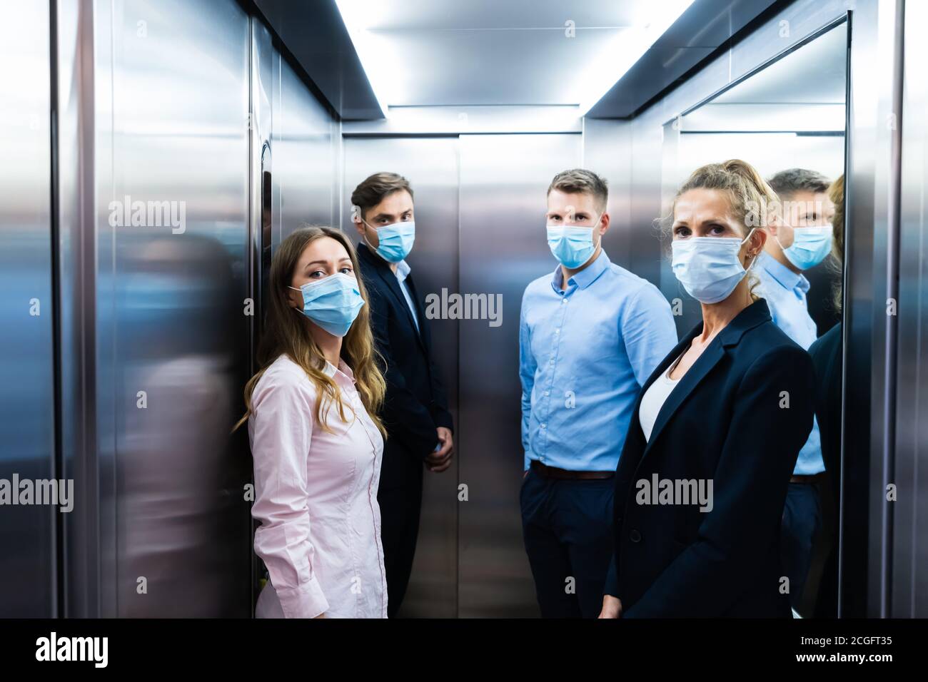 Group Of People In Elevator Wearing Face Masks Stock Photo