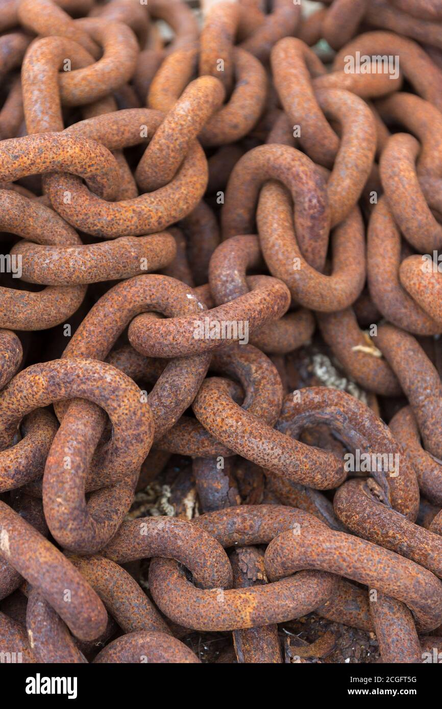 A long rusty chain heaped into a pile Stock Photo