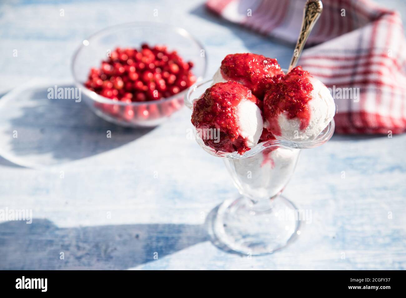 Balls of vegan chickpea ice cream in a glass bowl with cranberries on a light background. Horizontal orientation. Place for copy space Stock Photo