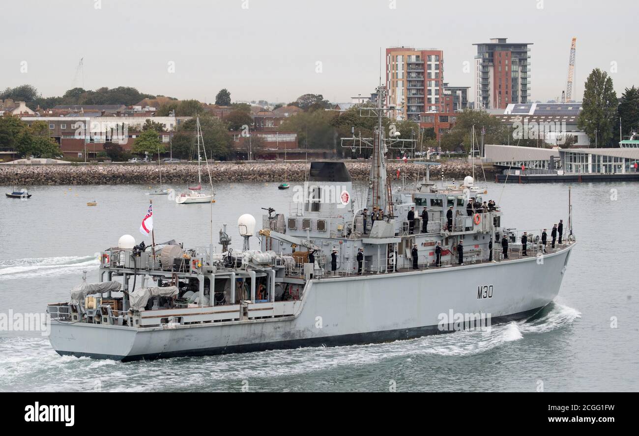 Crew members line the deck of HMS Ledbury as she returns to Portsmouth