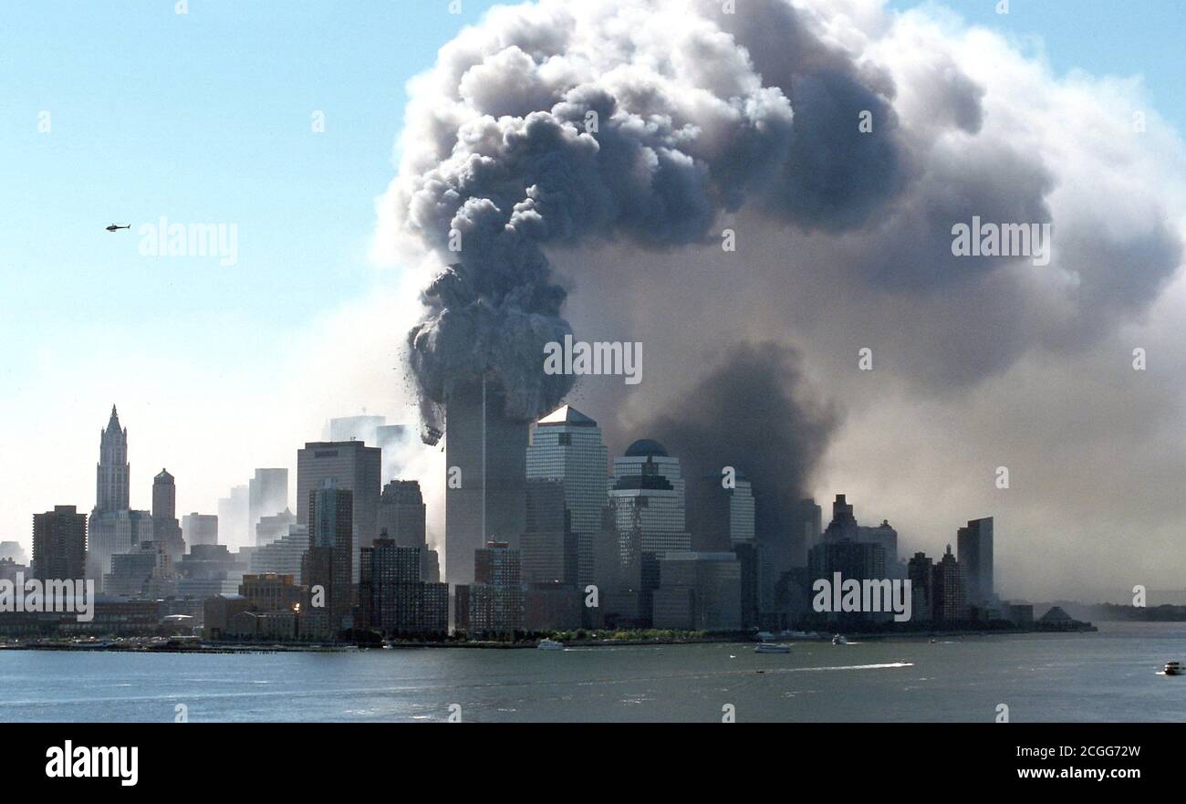 Thick black smoke emerges from the burning towers of the World Trade Center in the New York borough of Manhattan on the morning of 9/11/2001. Wreckage and building parts of the 411 meter high twin towers fly onto the street. Shortly before, two aircraft had raced one behind the other into the two towers. Apart from the occupants of the machines, most of the people inside the two skyscrapers were killed in the heavy explosions. The FBI walks on suspicion that it is a targeted attack by terrorist suicide bombers. The upper parts of the skyscrapers went up in flames after explosions. The machin Stock Photo