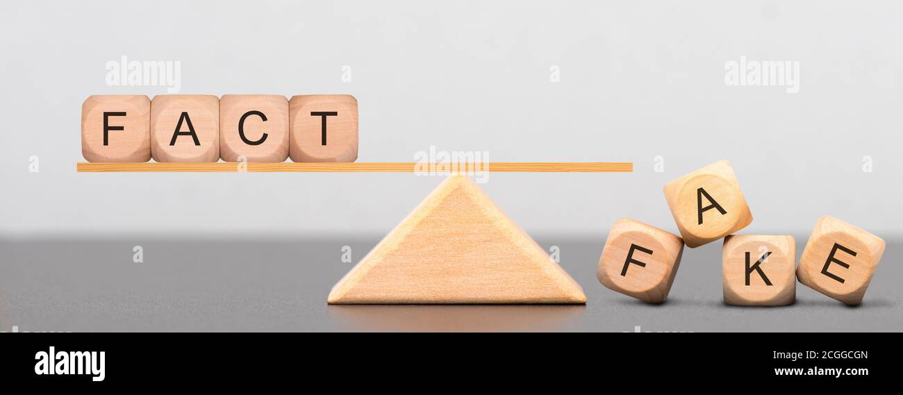 fact and fake news written on wooden cubes Stock Photo
