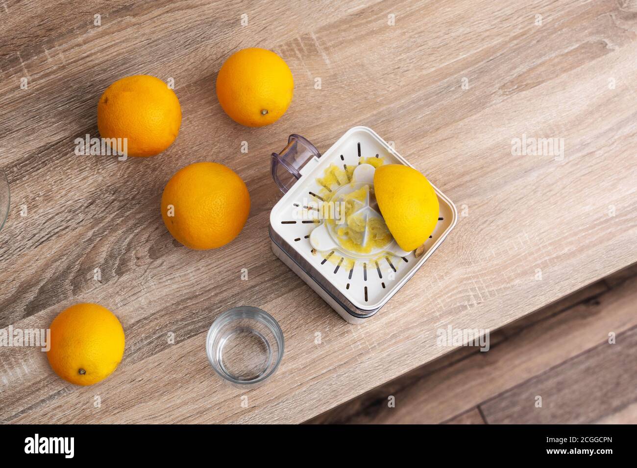 Woman squeezing oranges in the kitchen Stock Photo