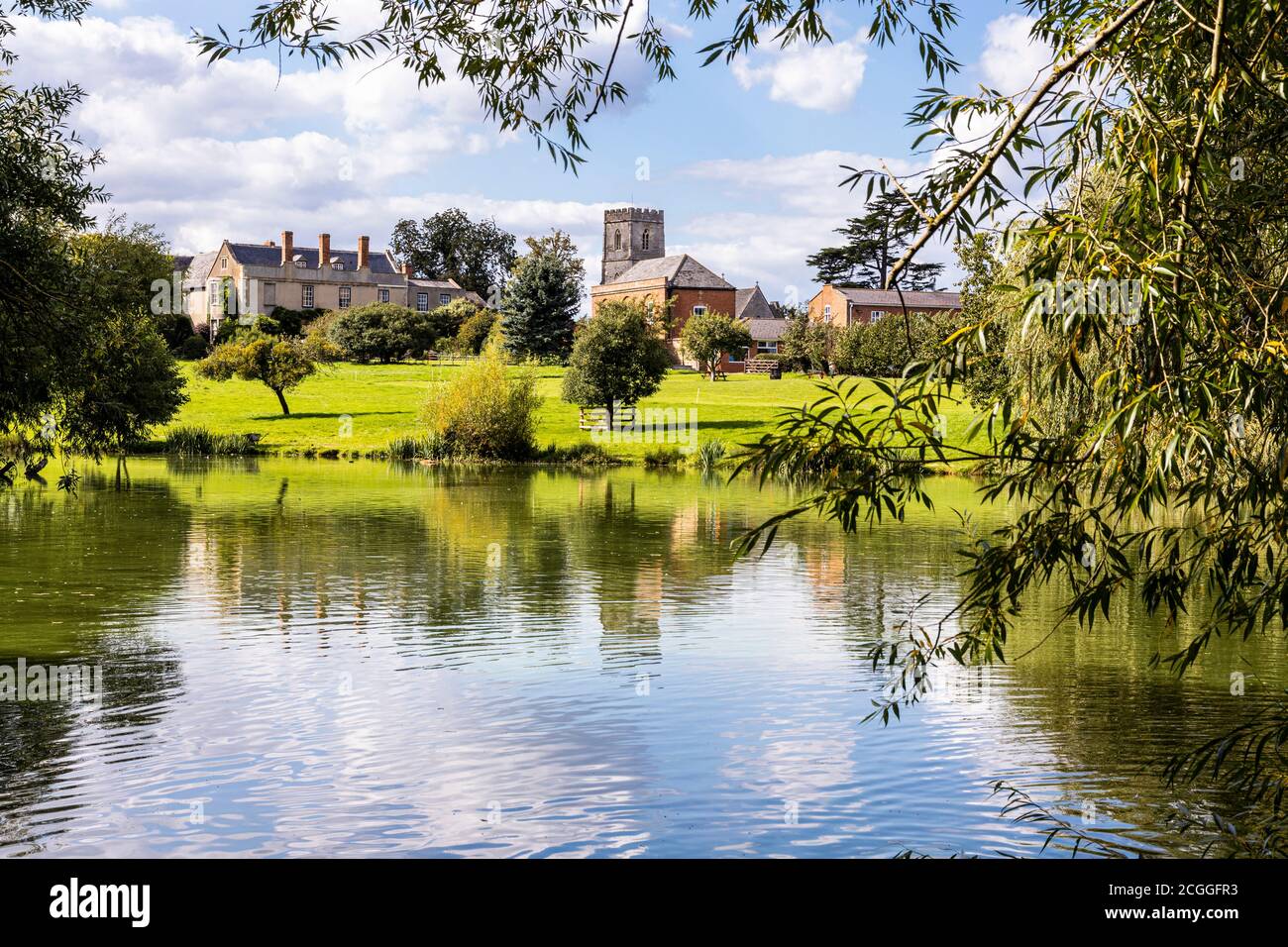 Maisemore Court and St Giles church viewed across the lake in the Severn Vale village of Maisemore, Gloucestershire UK Stock Photo