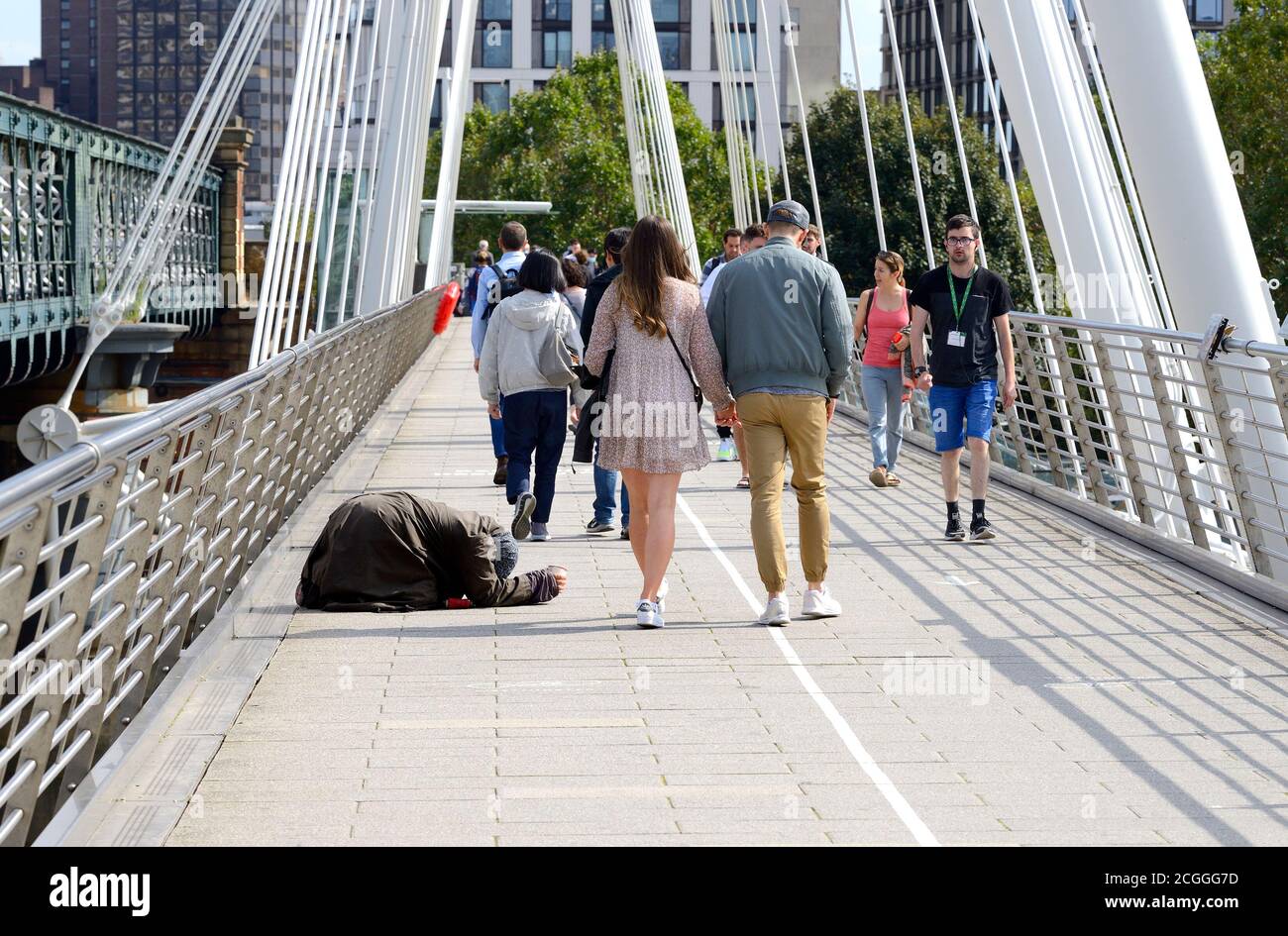 London, England, UK. Homeless woman begging on the Golden Jubilee Bridge across the Thames Stock Photo