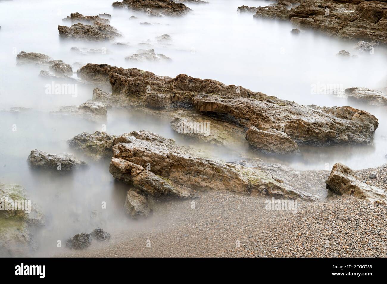 Long exposure photography with a neutral density filter. Beach in Asturias, Spain with a cloudy sunrise. Stock Photo