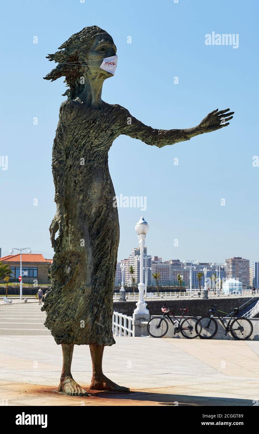 Monument To The Emigrant's Mother with facial mask on San Lorenzo beach, Gijon, Asturias, Spain. Stock Photo