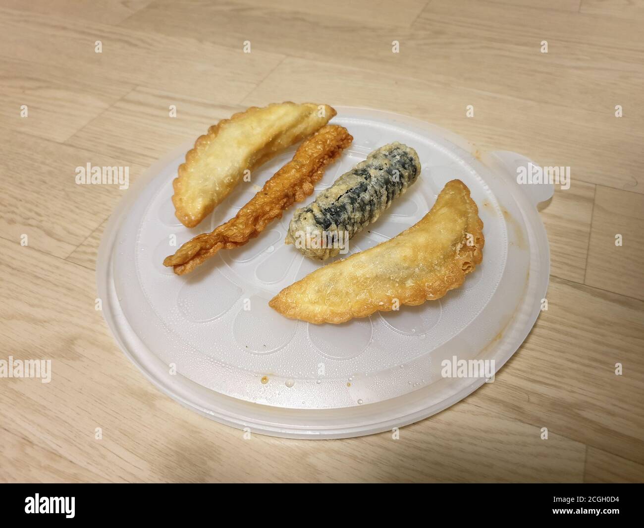 Twigim - Korean style deep fried food. Mandu - Korean dumpling. Gimmari - Seaweed spring rolls stuffed with glass noodle. Eomuk, or Oden - Fish cake. Stock Photo