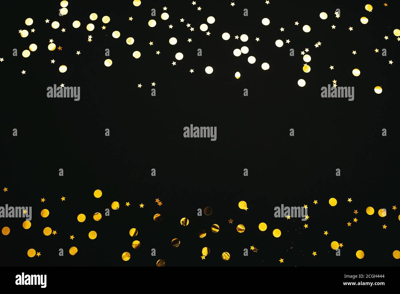 Gold and silver confetti on a black festive background. In the middle ...