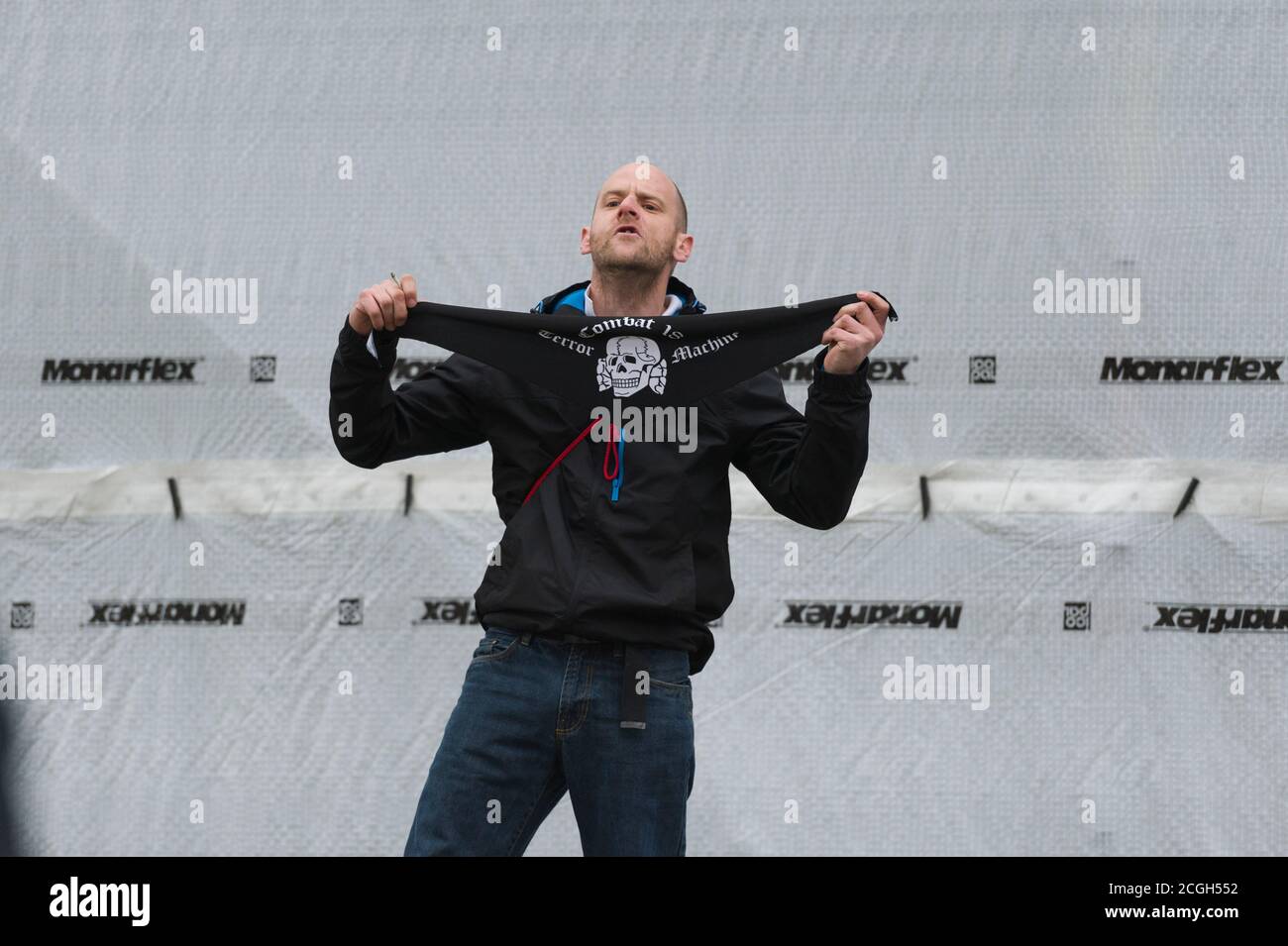 A Pegida supporter holding a combat 18 scarf at the UK branch of Anti-islamisation group Pegida (Patriotic Europeans Against the Islamisation of the West) first rally in London, to protest against what they say is Islamisation of Britain. The Pegida rally was held near Downing Street. Less than100 people came out to support Pegida rally they where heavily out number by an anti Pegida protesters. Pegida started in Dresden Germany in October 2014, Patriotic Europeans Against the Islamisation of the Occident (German: Patriotische Europäer gegen die Islamisierung des Abendlandes), abbreviated Peg Stock Photo