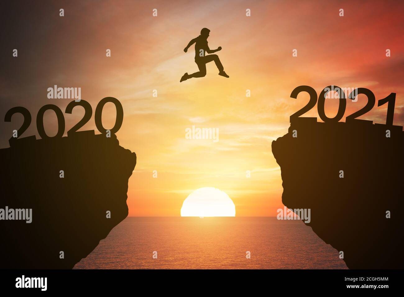 silhouette man jump from the mountain from 2020 to 2021 years with the sunset or sunrise background. Happy and success growth with new year 2021 conce Stock Photo