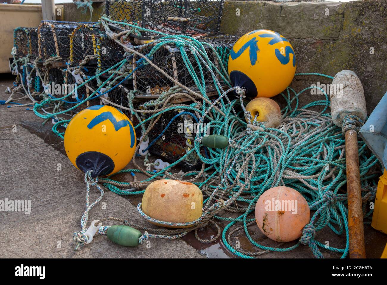 Lobster pots on a quay side waiting to be loaded onto a fishing boat Stock Photo