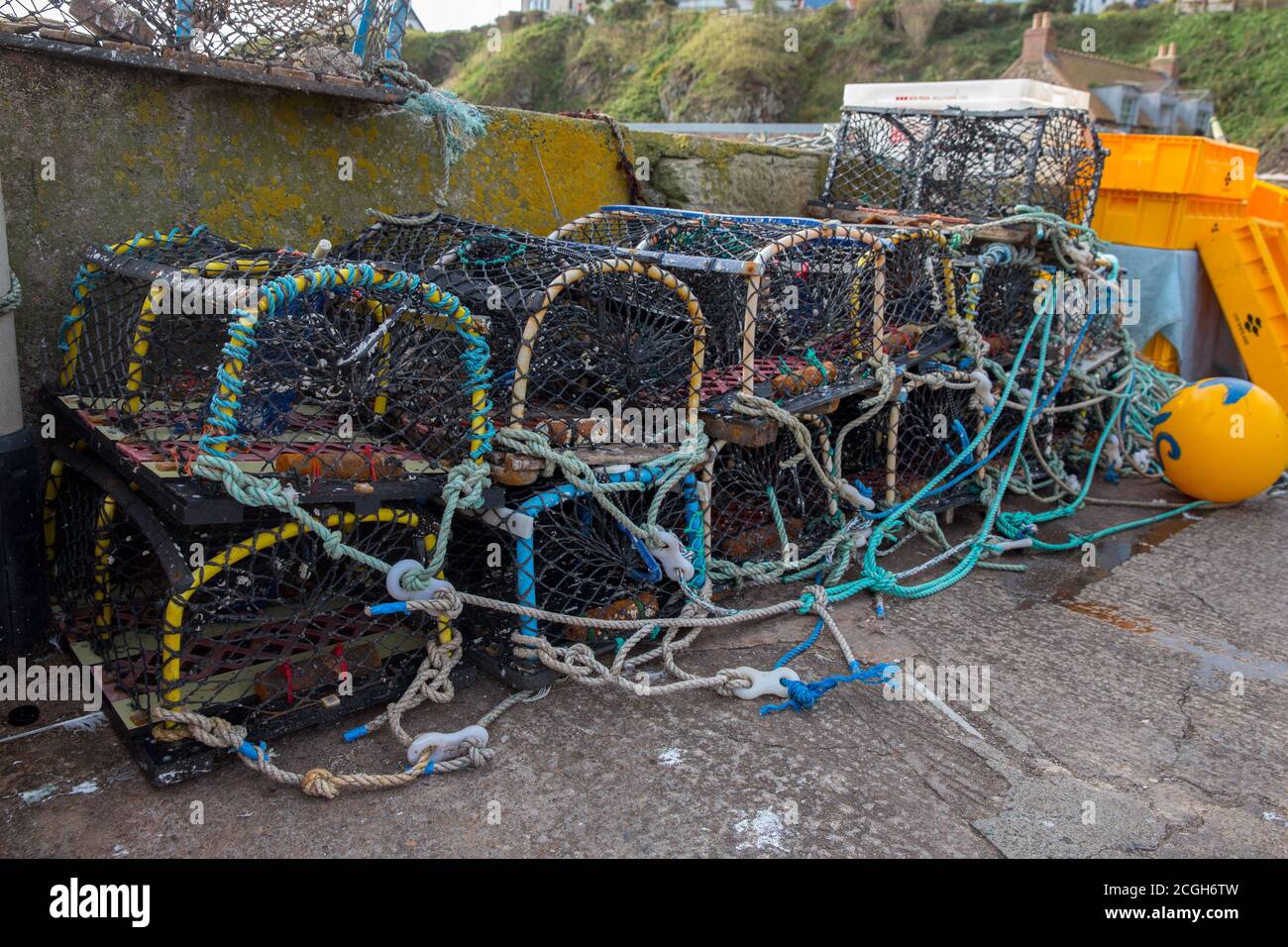 Lobster pots on a quay side waiting to be loaded onto a fishing boat Stock Photo
