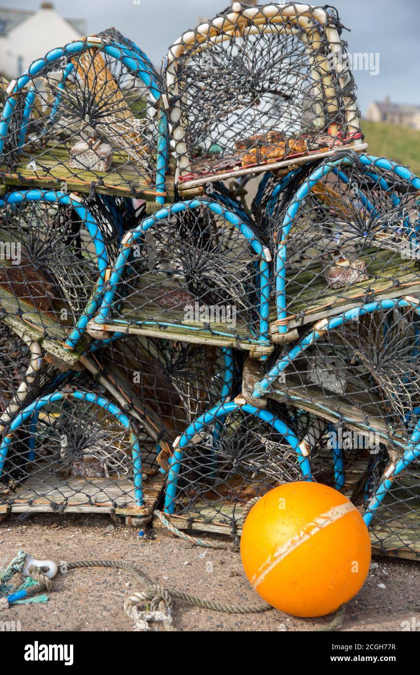 Lobster pots on a quay side waiting to be loaded onto a fishing boat Stock Photo