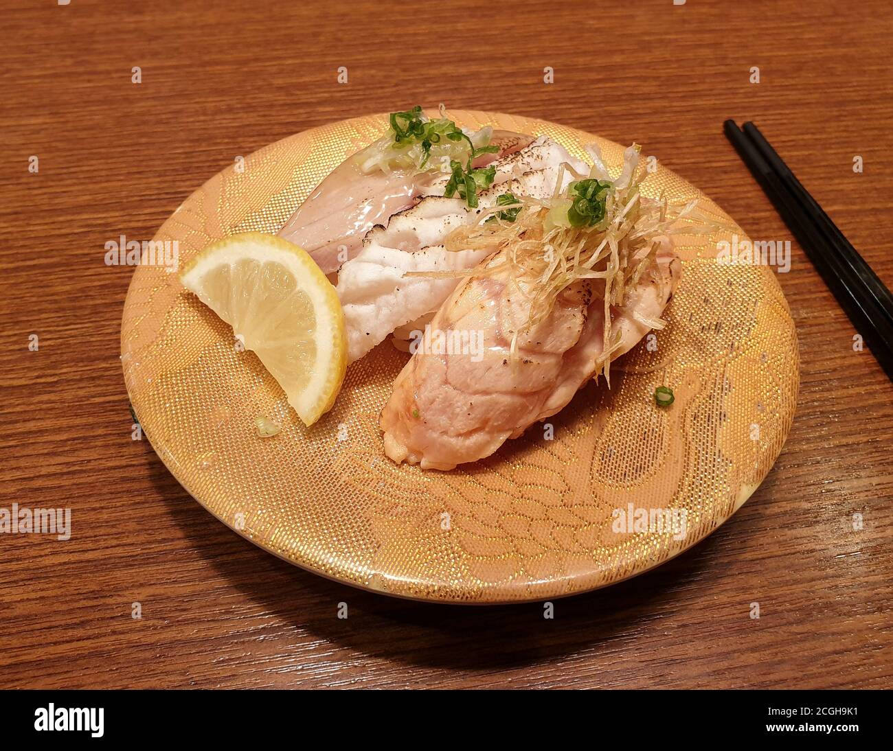 Sushi topped with slightly grilled raw fish and vegetable. Popular conveyor belt sushi restaurant in Seoul. Stock Photo