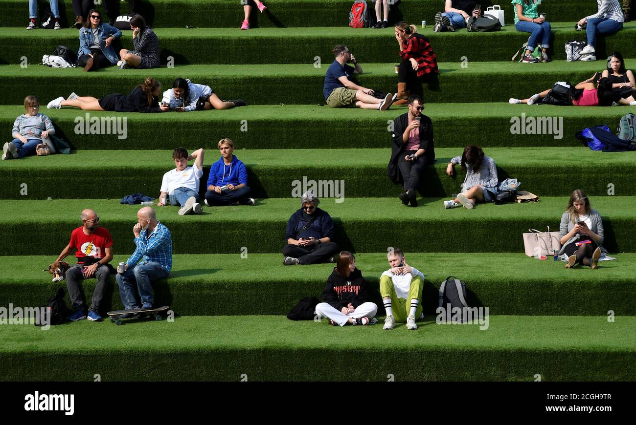 People are seen relaxing in an outdoor seating area, whilst the reproduction 'R' number of COVID-19 infections in the United Kingdom has risen and may be above 1, the Government Office for Science said on Friday, indicating a risk that the overall epidemic is growing, London, Britain, September 11, 2020. REUTERS/Toby Melville Stock Photo