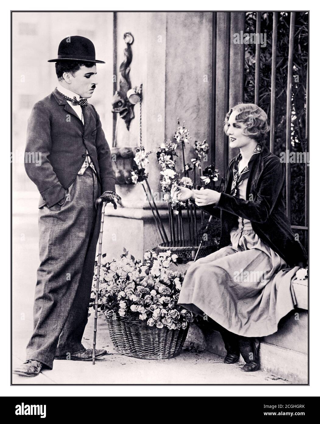 Archive Charlie Chaplin promotional photograph for Charlie Chaplin's 1931 film City Lights, depicting Chaplin as the Tramp and his co-star Virginia Cherrill as the Blind Flower Girl. The still is taken from the first scene with the blind flower girl, which was first shot sometime between December 27, 1928, and April 1929, then reshot in late 1929. This image is most likely from the later reshoots. This promotional copy was created on January 2, 1931, and the film itself was released in January 30, 1931. Stock Photo