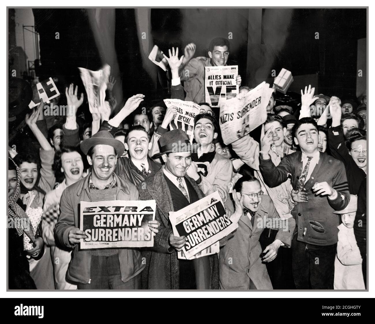 VE DAY 1945 Archive VE day WW2 celebrations with Americans holding newspaper headlines proclaiming ‘Germany Surrenders’  VE Day Friday 8 May 1945 Nazi Germany's formal surrender towards the end of the Second World War. On VE (Victory in Europe) Day in 1945, millions took to the streets to celebrate peace in our time. Stock Photo
