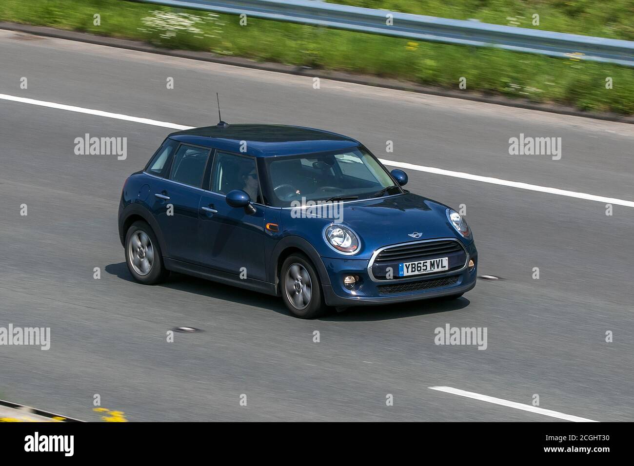 A 2015 Mini Cooper Blue Car Hatchback driving on the M6 motorway near Preston in Lancashire, UK Stock Photo