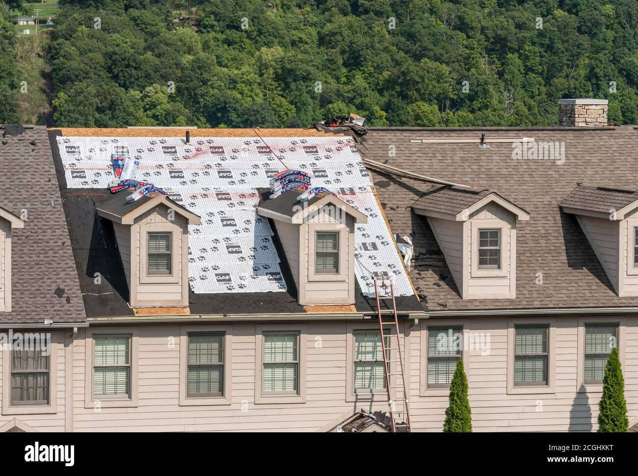 Morgantown, WV - 10 September 2020: Roofing contractor has laid waterproof liner on townhouse roof before adding the new shingles Stock Photo