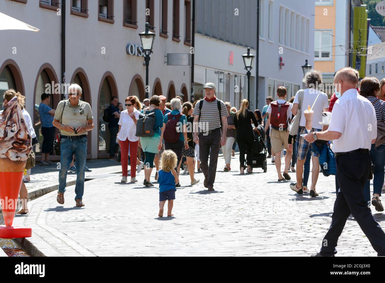Freiburg im Breisgau, Rathausgasse with passers-by and barefoot child Stock Photo