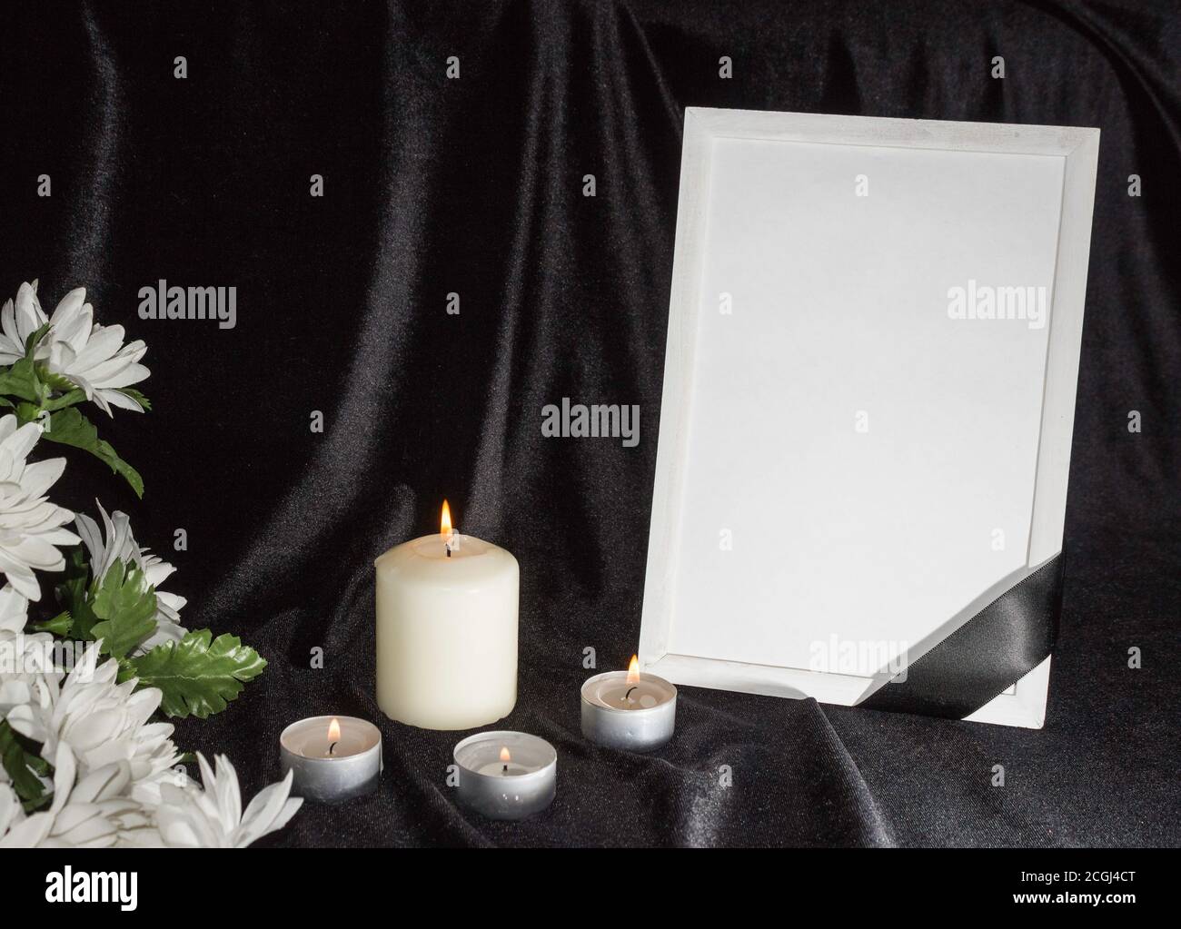 The concept of wake. Candles and white flowers on a black background