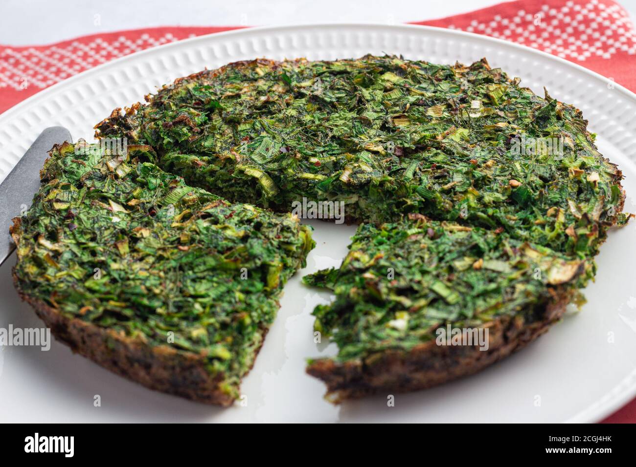 Kuku sabzi | Persian herb frittata slices on a plate Stock Photo