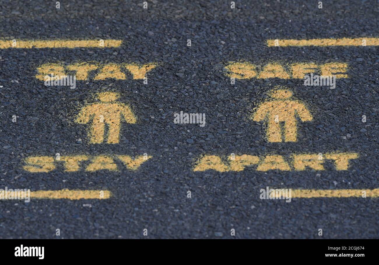Public health signs are seen sprayed on a pavement, whilst the reproduction 'R' number of COVID-19 infections in the United Kingdom has risen and may be above 1, the Government Office for Science said on Friday, indicating a risk that the overall epidemic is growing, London, Britain, September 11, 2020. REUTERS/Toby Melville Stock Photo