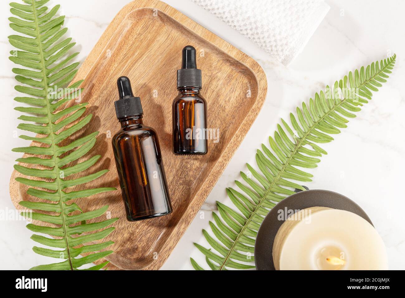 Essential oil bottle on wooden tray. Beauty, skin care, wellness Stock Photo