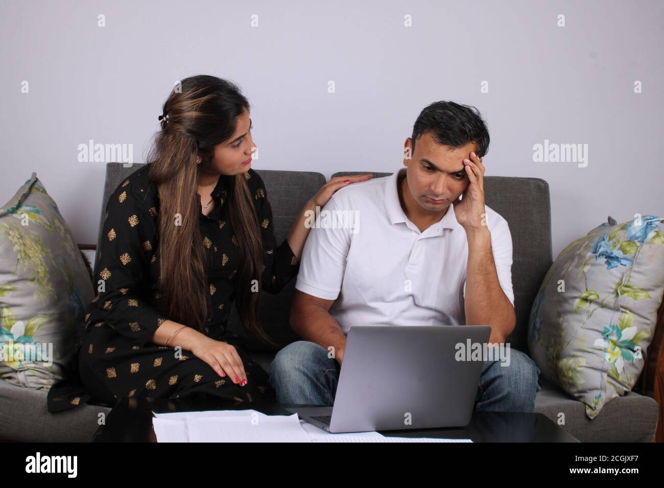 Upset couple looking at laptop on white background Stock Photo