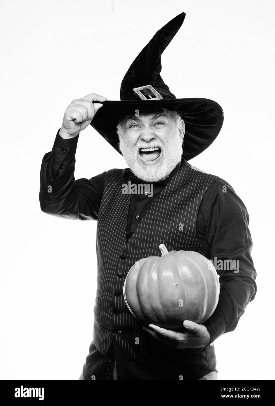 happy halloween. evil wizard hold orange pumpkin. Stargazer in holiday costume. Traditional food. bearded man ready for halloween party. mature man magician in witch hat. halloween decoration. Stock Photo