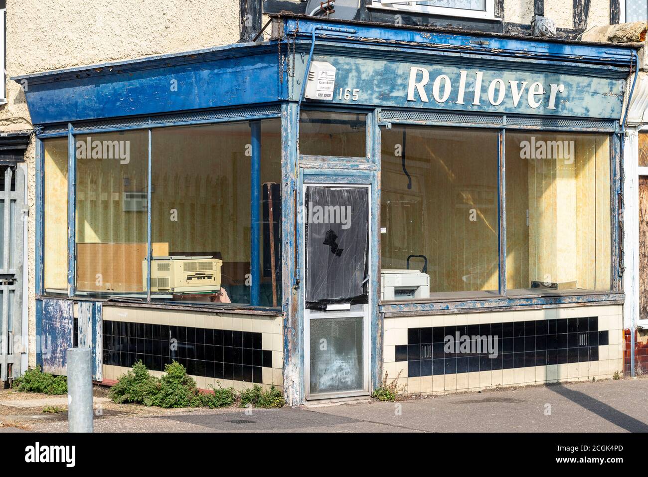 Decaying empty shop named Rollover, in Westcliff on Sea, Southend, Essex, UK. Long term vacant dilapidated business property with old equipment left Stock Photo
