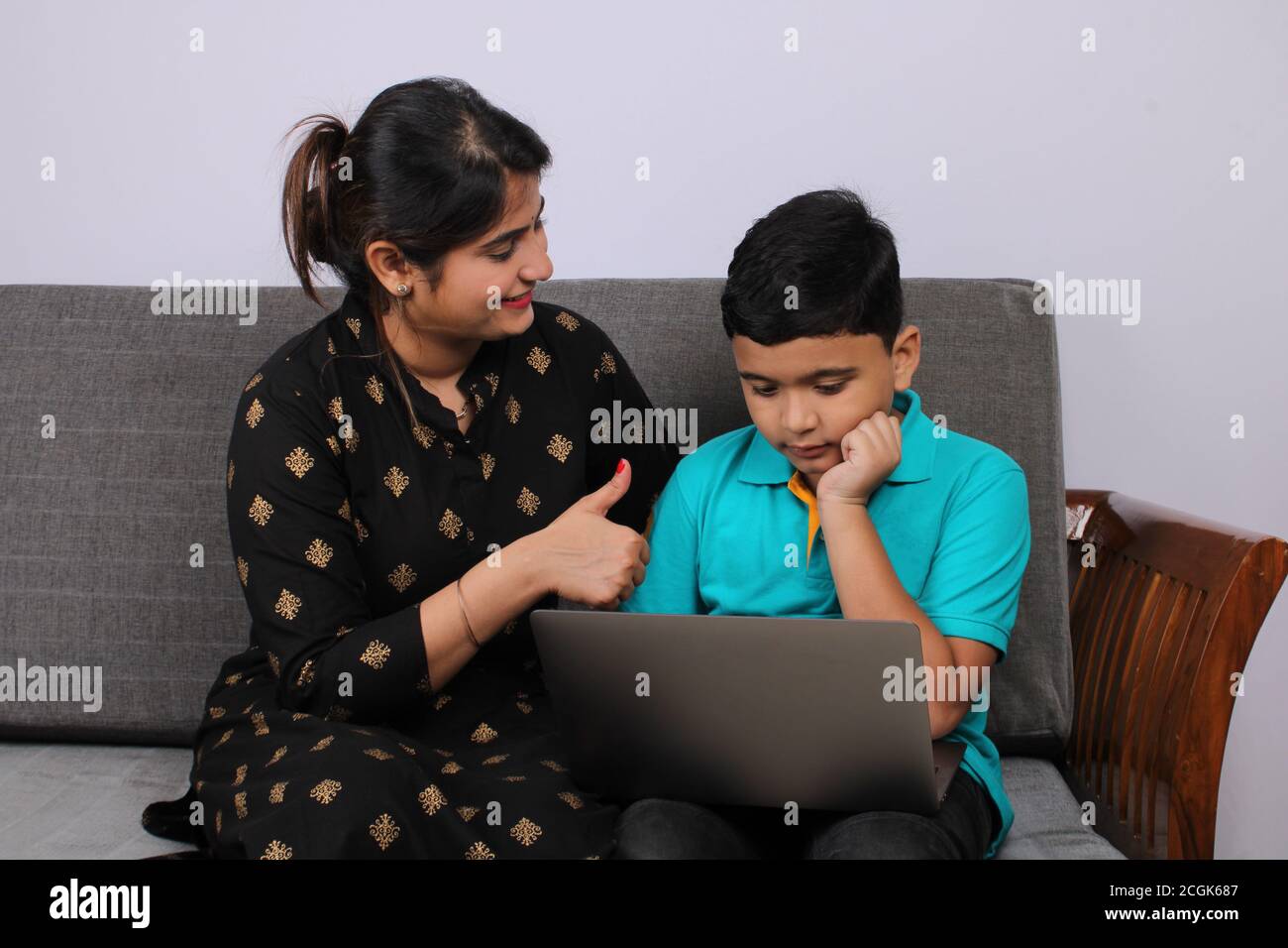 Coronavirus Outbreak and education concept - Lockdown and school closures. Indian Mother helping son studying online classes at home. COVID-19 Stock Photo