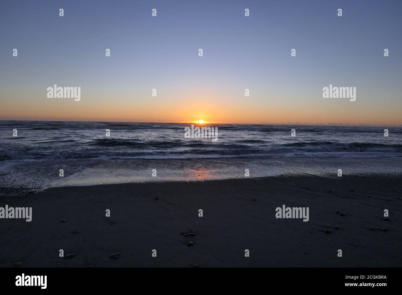 Far advanced sunset on a beach in New Zealand Stock Photo