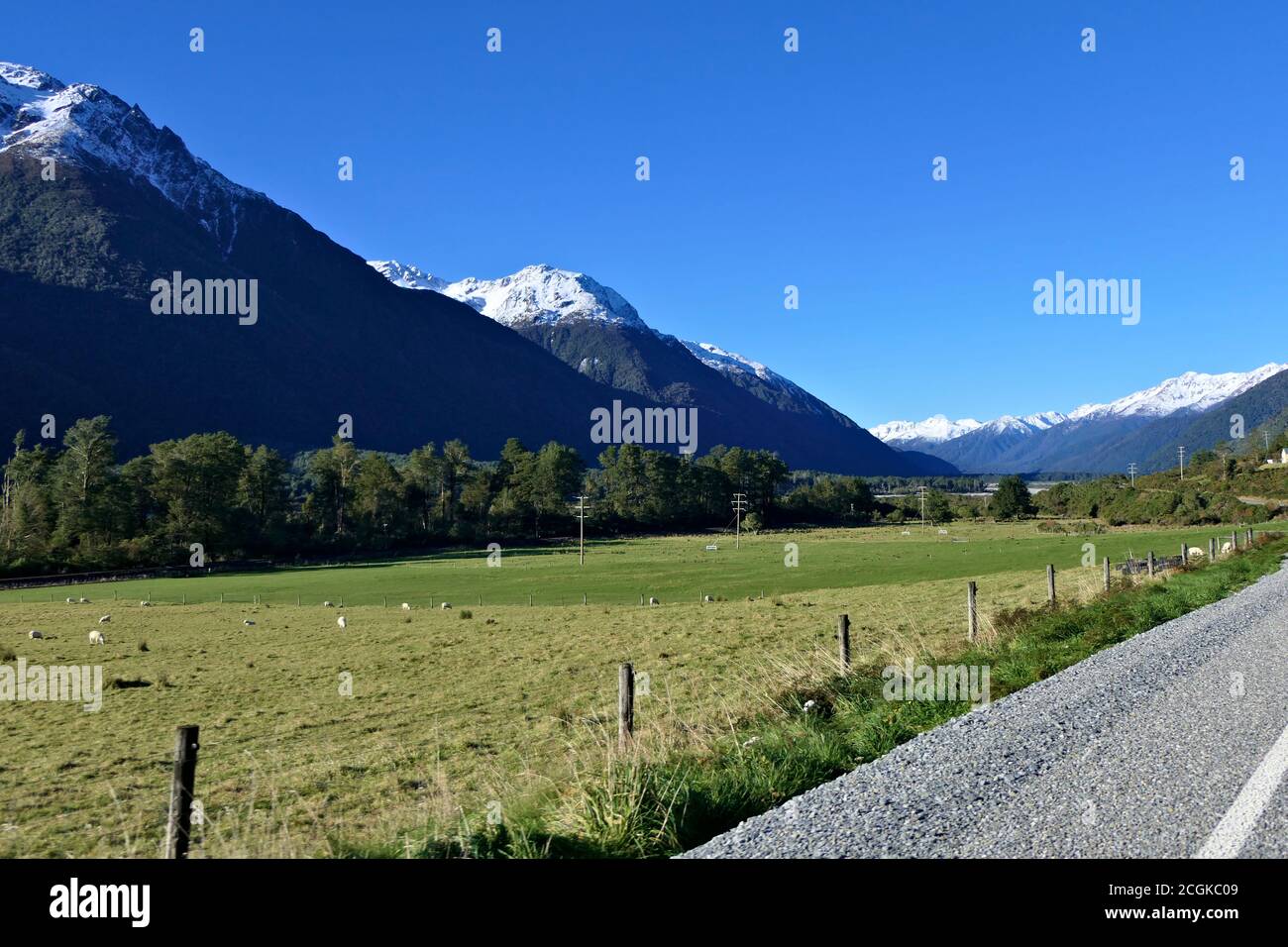 Mountain road in the Southern Alps in New Zealand on a winter day with a clear blue sky and snowy peaks Stock Photo