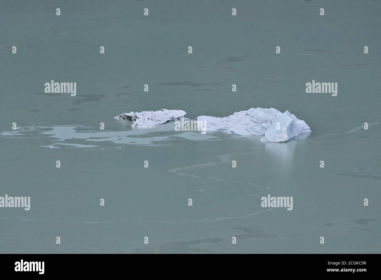 Global warming - closeup melting block of ice or ice berg on a frozen blue lake Stock Photo