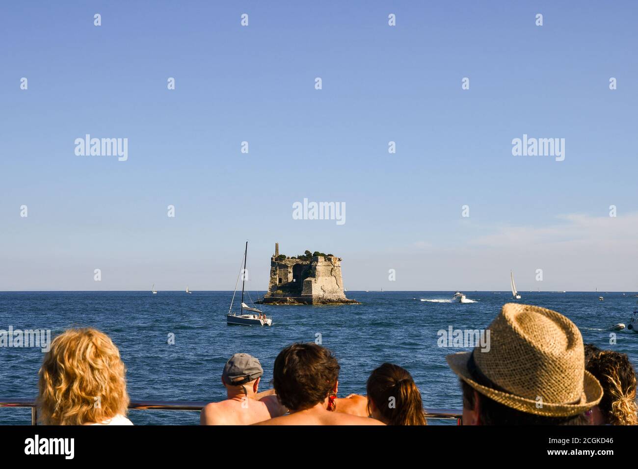 Tourists on a ferry admiring the Scola Tower, an old fortress (17th century) built on a rock surrounded by the sea, Porto Venere, La Spezia, Italy Stock Photo
