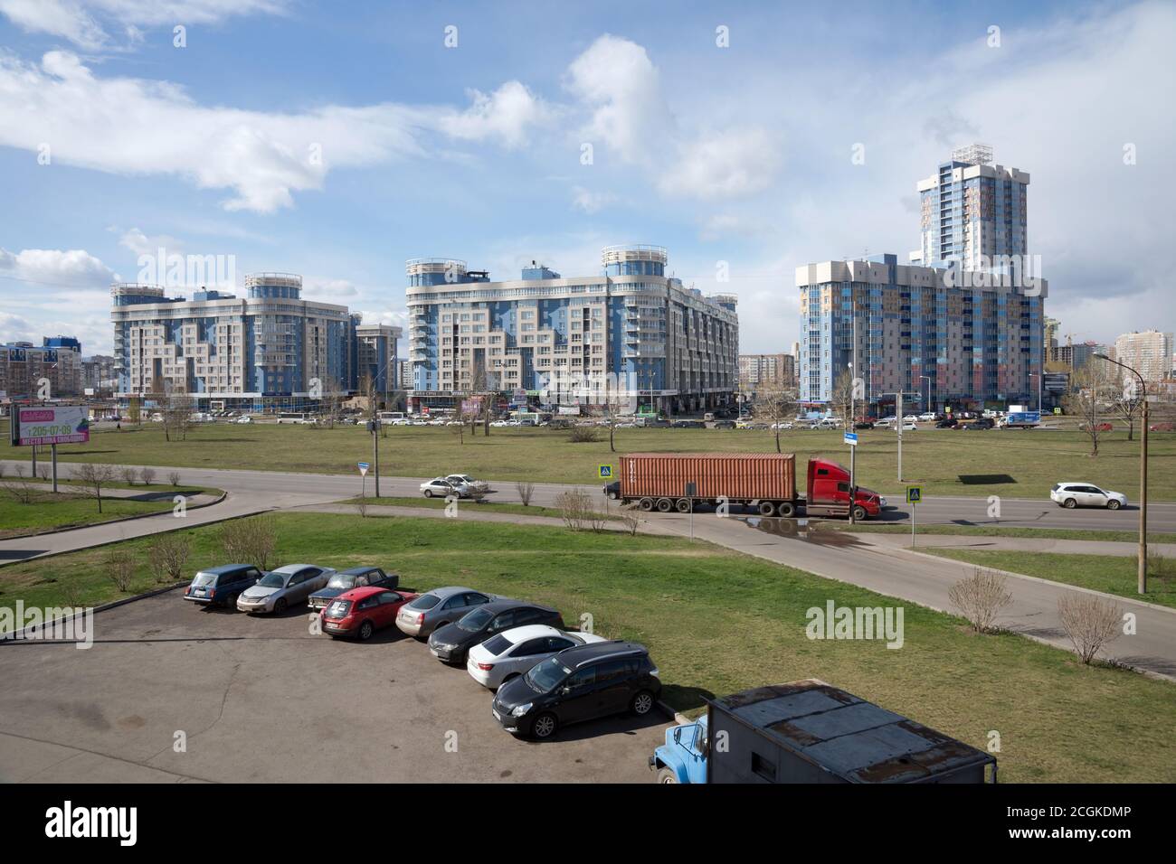 View of district 'Northern' of the  Krasnoyarsk city overlooking the dwelling houses and parking spaceat the Prospect Aviatorov in the spring. Stock Photo