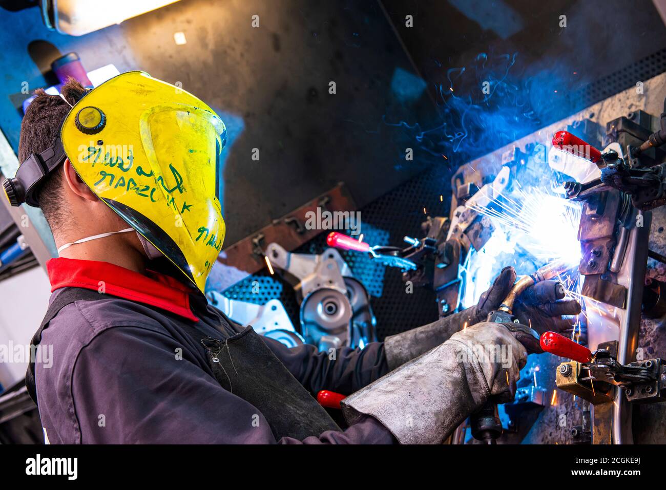 Side view of mechanic welding truck in auto repair shop. Stock Photo