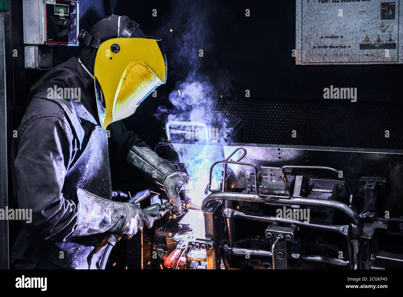 Man Welding on Assembly Line in Automotive Factory . Stock Photo