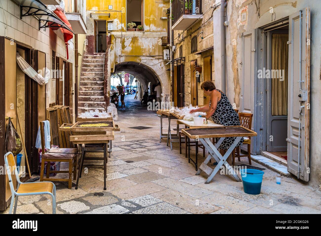 BARI, ITALY - SEPTEMBER 1, 2020: housewives making orecchiette in the streets of Bari Vecchia Stock Photo