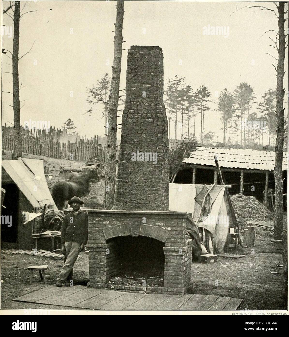 . The photographic history of the Civil War : in ten volumes . EVIEW OF REVIEWS CO. CAMP IS UROKEX—THE ARMY ADVANCES To secure for Grant the fullest yiossible information about Lees movements was the task of General Sharp,Chief of the Secret Service of the Army, whose deserted headquarters at Brandy Station, Va., in April, 1864,are shown in this photograph. Here are the stalls built for the horses and the stockade for prisoners. Thebrick fireplace that had lent its cheer to the generals canvas house is evidence of the comforts of an armysettled down for the respite of winter. Regretfully do so Stock Photo