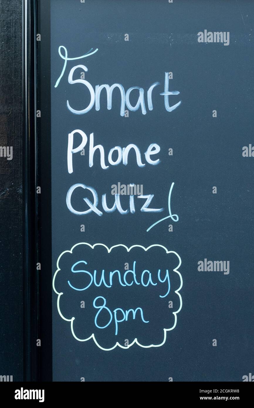 Smart phone quiz sunday 8pm on a blackboard notice board outside a pub, UK Stock Photo