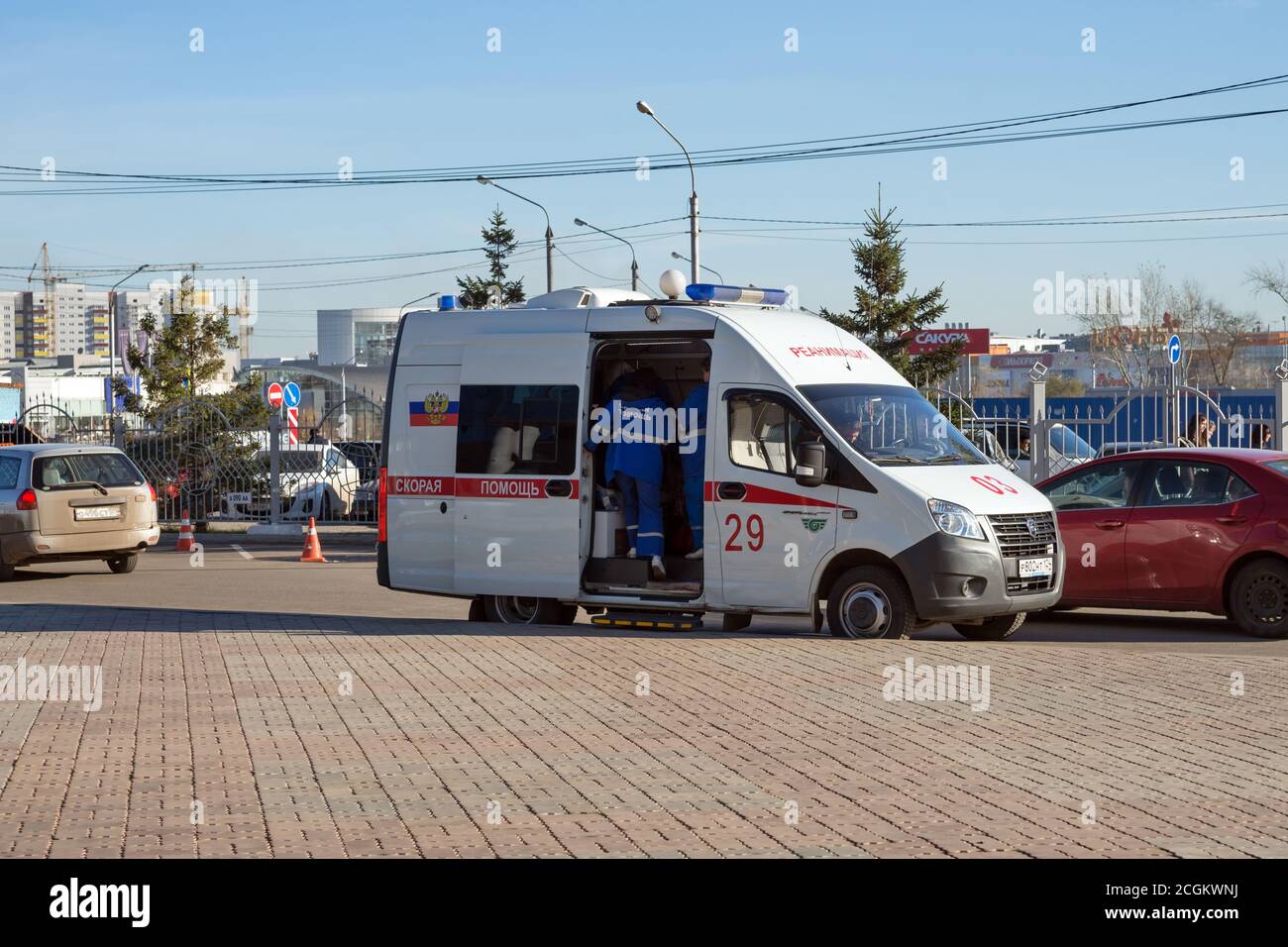 A doctor will climb into a white ambulance that stands in the Northern district of Krasnoyarsk, near the parking lot in the fall Stock Photo