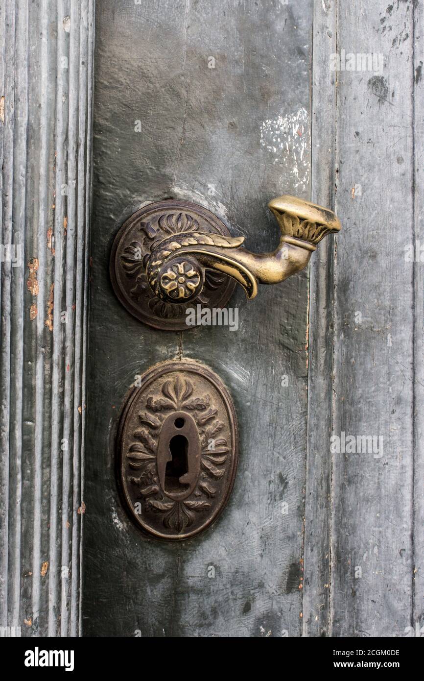 Historic old brass door handle on a wooden door Stock Photo