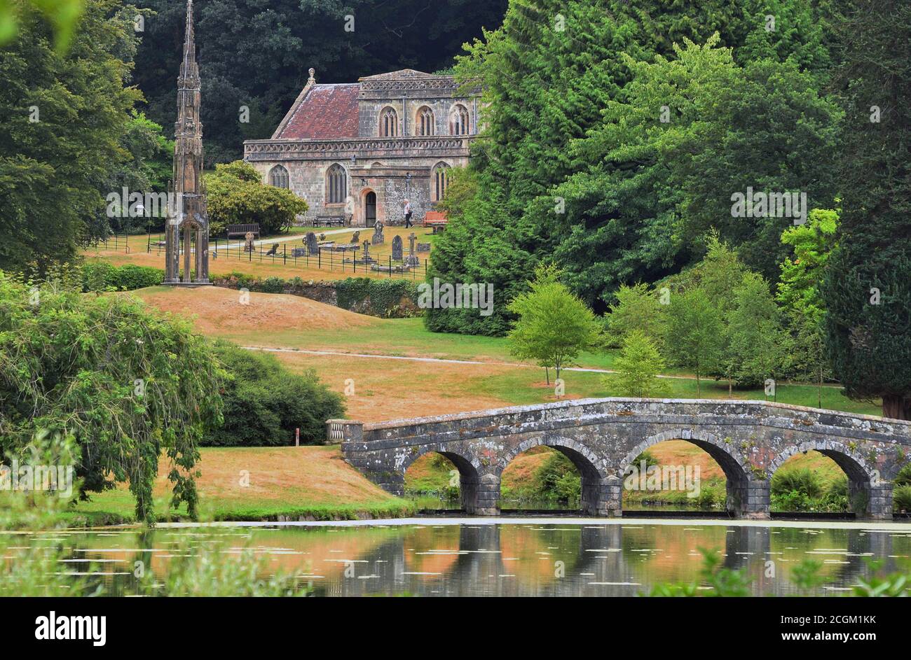 St Peter's Church, the Bristol High Cross and the Palladian Bridge viewed from across the lake on the Stourhead Estate, near Mere, Wiltshire, England Stock Photo