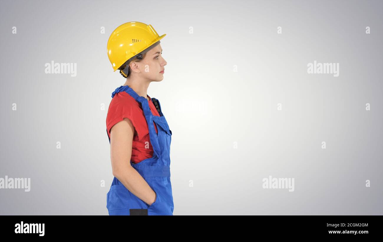 Construction worker lady walking emotionless on gradient backgro Stock Photo